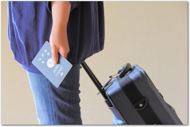 スーツケースを持って海外旅行に出発する女性