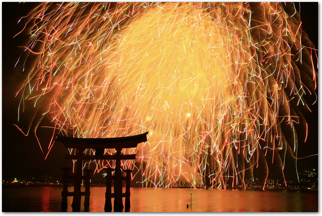 宮島の花火大会で水に映える打ち上げ花火と鳥居